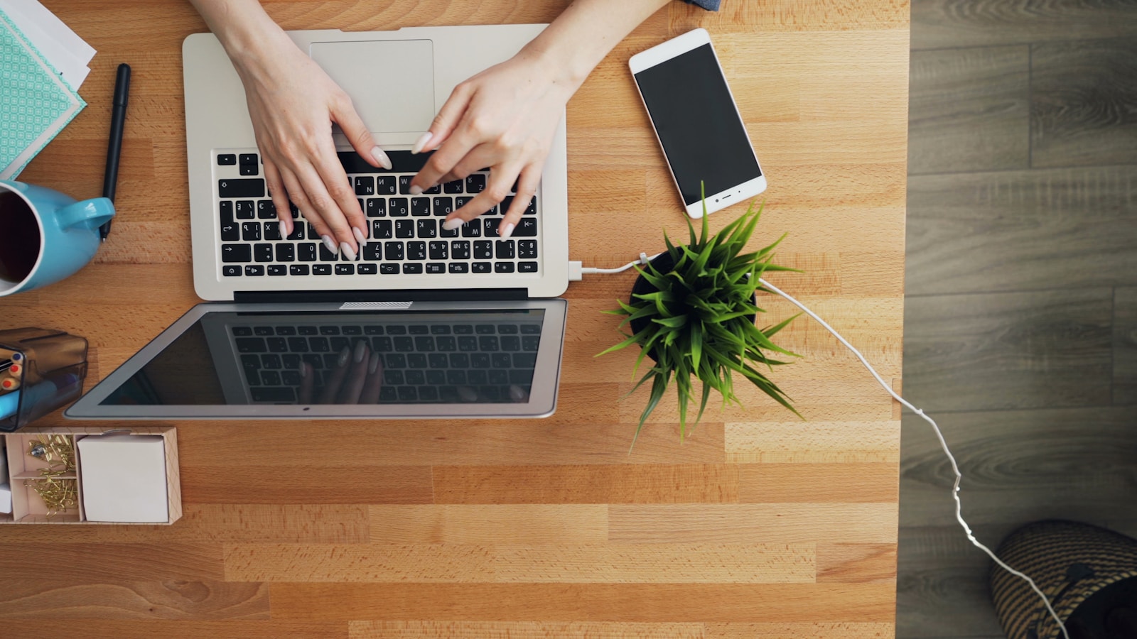 a person typing on a laptop on a wooden table